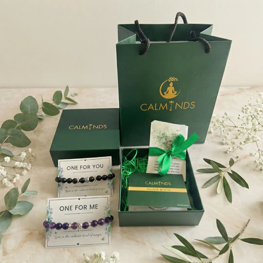 Green 'CALMINDS' packaging with bracelets and a card on a light background