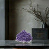 Purple crystal rock on a dark surface with a blurred background