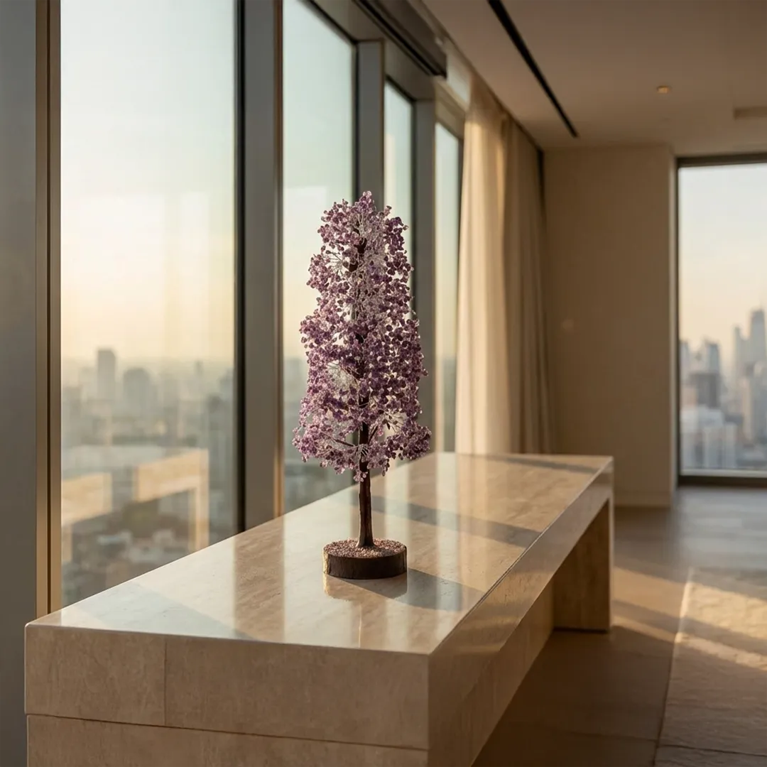 Decorative tree sculpture on a table with a cityscape view through large windows.