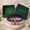 Two beaded bracelets on a stone surface with 'CALM NDS' branded boxes in the background.