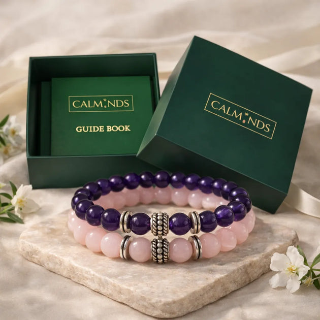 Two beaded bracelets on a stone surface with 'CALM NDS' branded boxes in the background.
