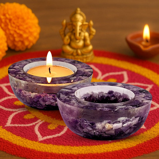 Amethyst candle holders with lit candles on a colorful mat with decorative elements.