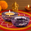 Amethyst candle holders with lit candles on a colorful mat with decorative elements.