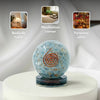 Decorative sphere with spiral design on a white pedestal, shown in various settings.