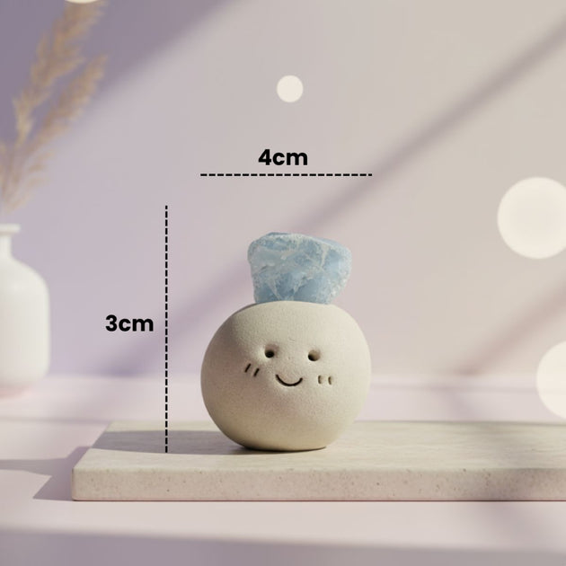Small round ceramic figure with blue aquamarine crystal on top and figure measurements on a light background