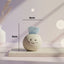 Small round ceramic figure with blue aquamarine crystal on top and figure measurements on a light background