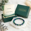 Green and blue beaded bracelet with 'Calminds' packaging and guide book on a white surface.
