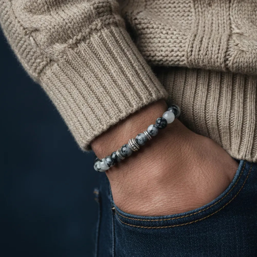 Person wearing a beaded bracelet on a dark background