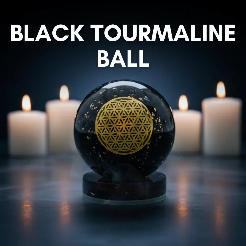 Black tourmaline ball with a gold symbol in front of lit candles on a dark background