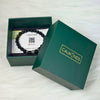 Open green box with a black beaded bracelet and card inside, branded 'CALMINDS'.