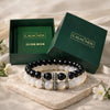 Set of black and white beaded bracelets with 'CALM.NDS' packaging on a light background