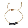golden thread bracelet with black beads on a white background
