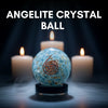 Blue crystal ball with a spiral design on a dark background with candles