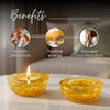 Two yellow candles on a surface with text indicating benefits like wealth attraction, positive energy, and success manifestation.