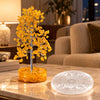 Citrine crystal tree beside a zodiac selenite charging plate on a living room table