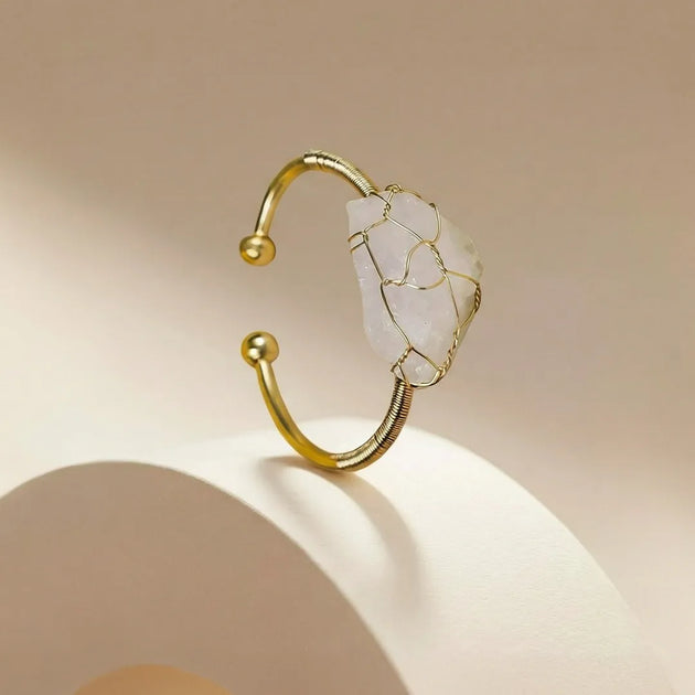 Gold and stone bracelet on a beige background