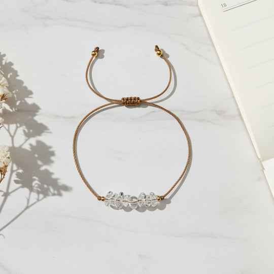 thread bracelet with clear quartz beads on a light background