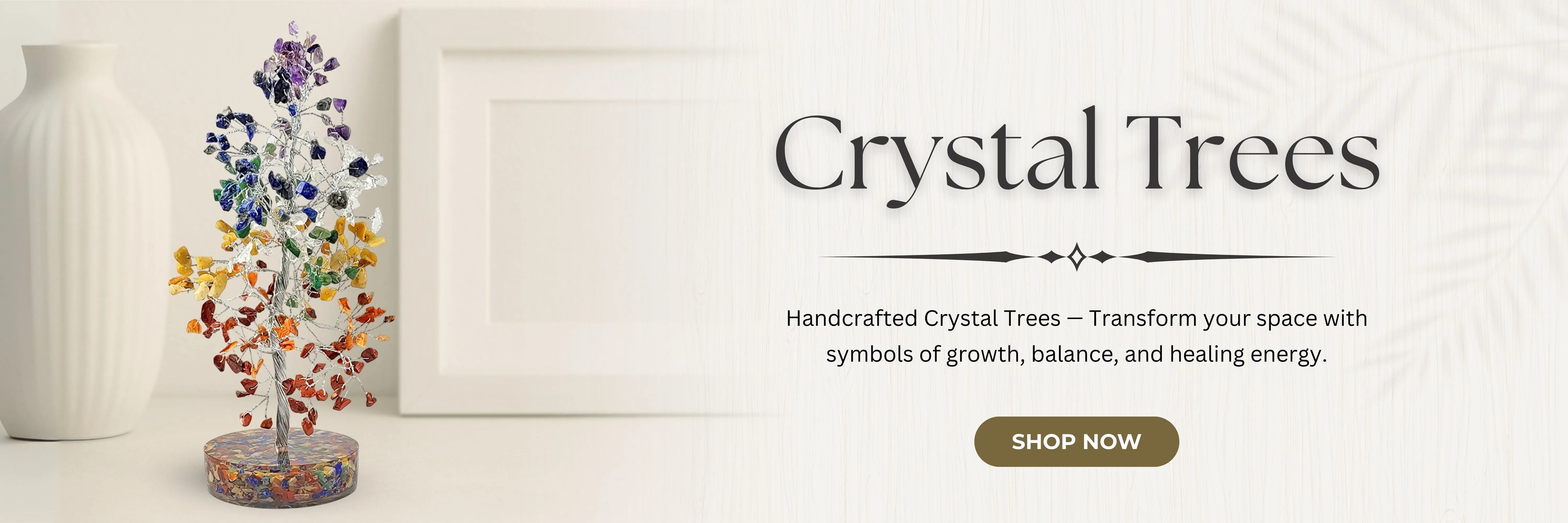 Crystal tree with colorful stones on a white surface, framed by a white wall.