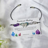 crystal bracelet with a butterfly charm on a white card with text, against a white background.