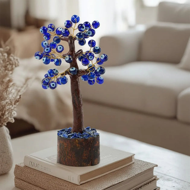Decorative tree with blue beads on a stack of books in a living room setting