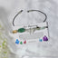 Bracelet with stones and a butterfly charm on a card labeled 'New Beginning' against a white background.