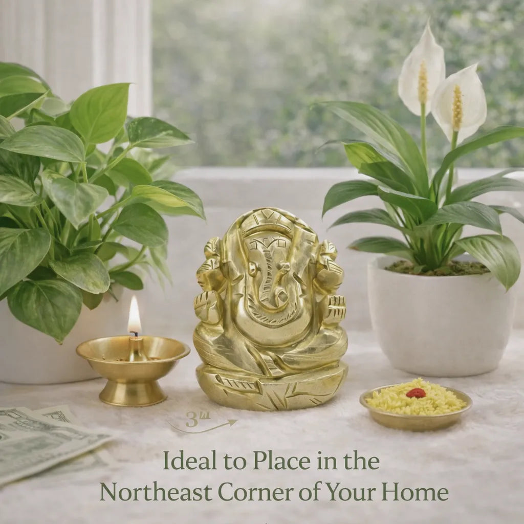 Gold Ganesha statue with plants and a candle on a table, ideal for the northeast corner of a home.