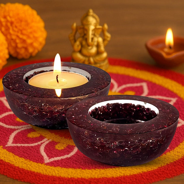 Decorative dark brown candle holders with lit candles on a colorful fabric background.