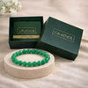 Green beaded bracelet on a stand with 'CALMINDS' branded box in the background