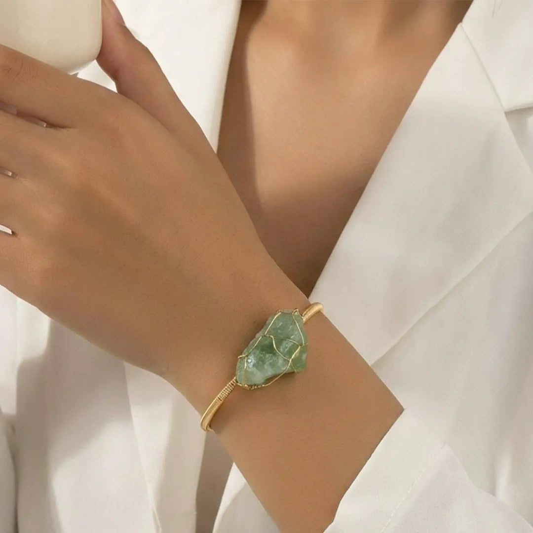 Green crystal bracelet on a person's wrist with a white background