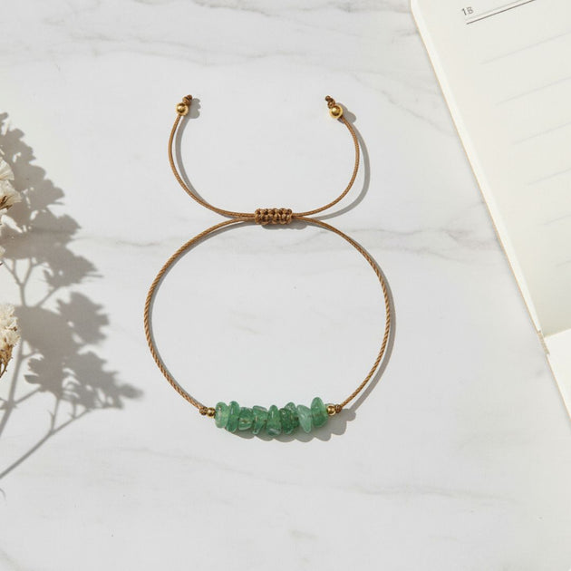 Bracelet with green beads on a light surface