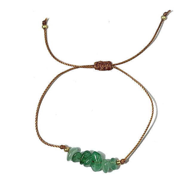 green avnturine crystal thread bracelet on a white surface