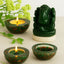 green jade ganesha and bloodstone candle holders with a lit candle and a ganesha statue on a light background