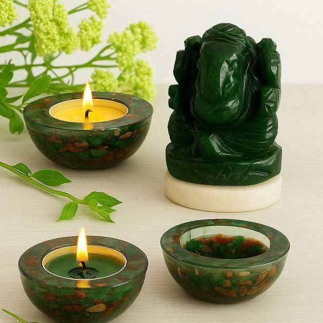green jade ganesha and green red crystal candle holders with a lit candle and a ganesha statue on a light background