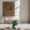 Green sculpture on a table in a living room with a neutral color palette