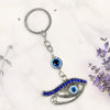 Keychain with eye design on a white background with lavender flowers