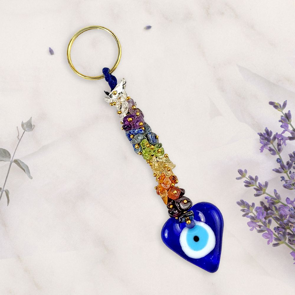 Colorful beaded keychain with a blue heart-shaped evil eye charm on a light background.