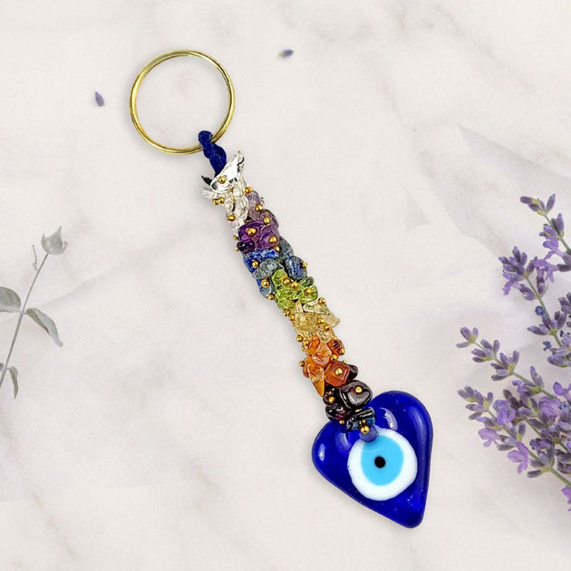 Colorful beaded keychain with a blue heart-shaped evil eye charm on a light background.