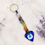 Colorful beaded keychain with a blue heart-shaped evil eye charm on a light background.