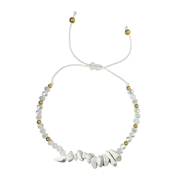 thread bracelet with white howlite stones and gold beads on a white background
