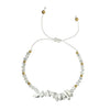 thread bracelet with white howlite stones and gold beads on a white background