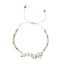 thread bracelet with white howlite stones and gold beads on a white background