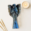 Decorative blue color angel sculpture with a candle and wooden skewers on a light surface
