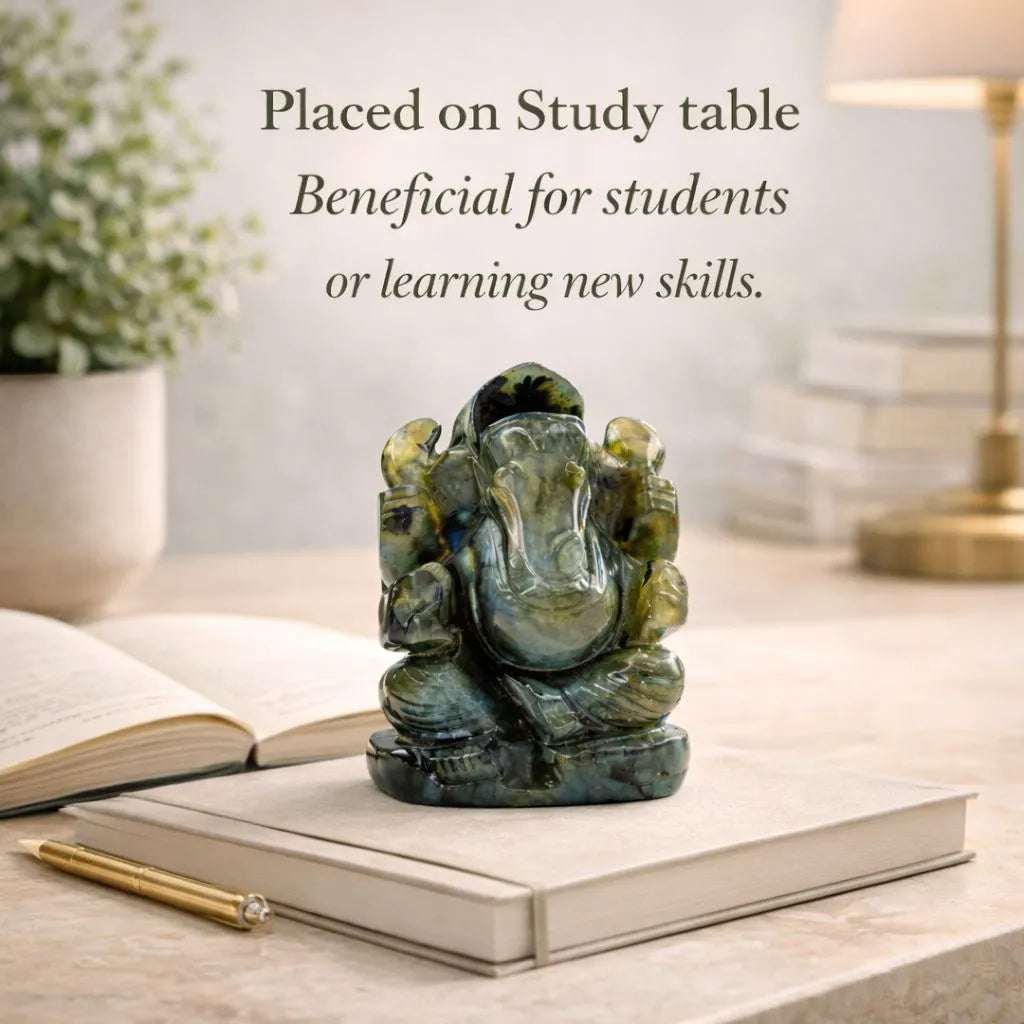 Green stone Ganesha statue on a book with text about its benefits for students or learning new skills.