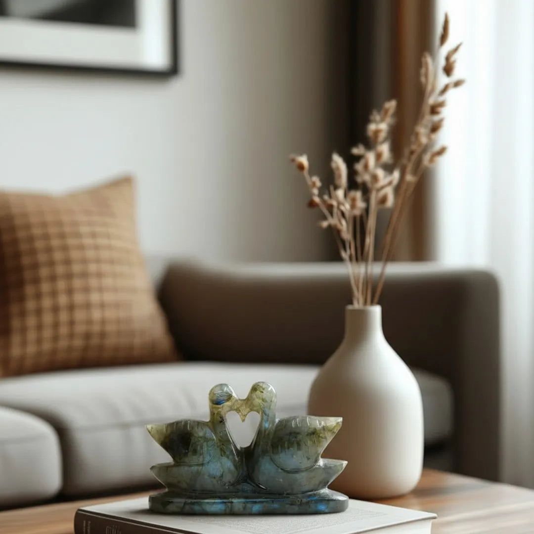 Decorative items on a table with a couch and framed picture in the background