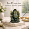Statue of Lord Ganesha on a book with incense and flowers in the background