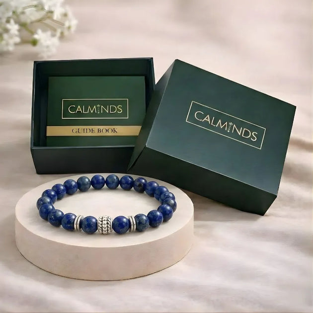 Blue beaded bracelet on a white stand with 'Calminds' branded box in the background