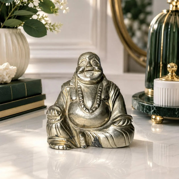 Natural Pyrite Laughing Buddha idol displayed on a marble table for wealth and positive energy
