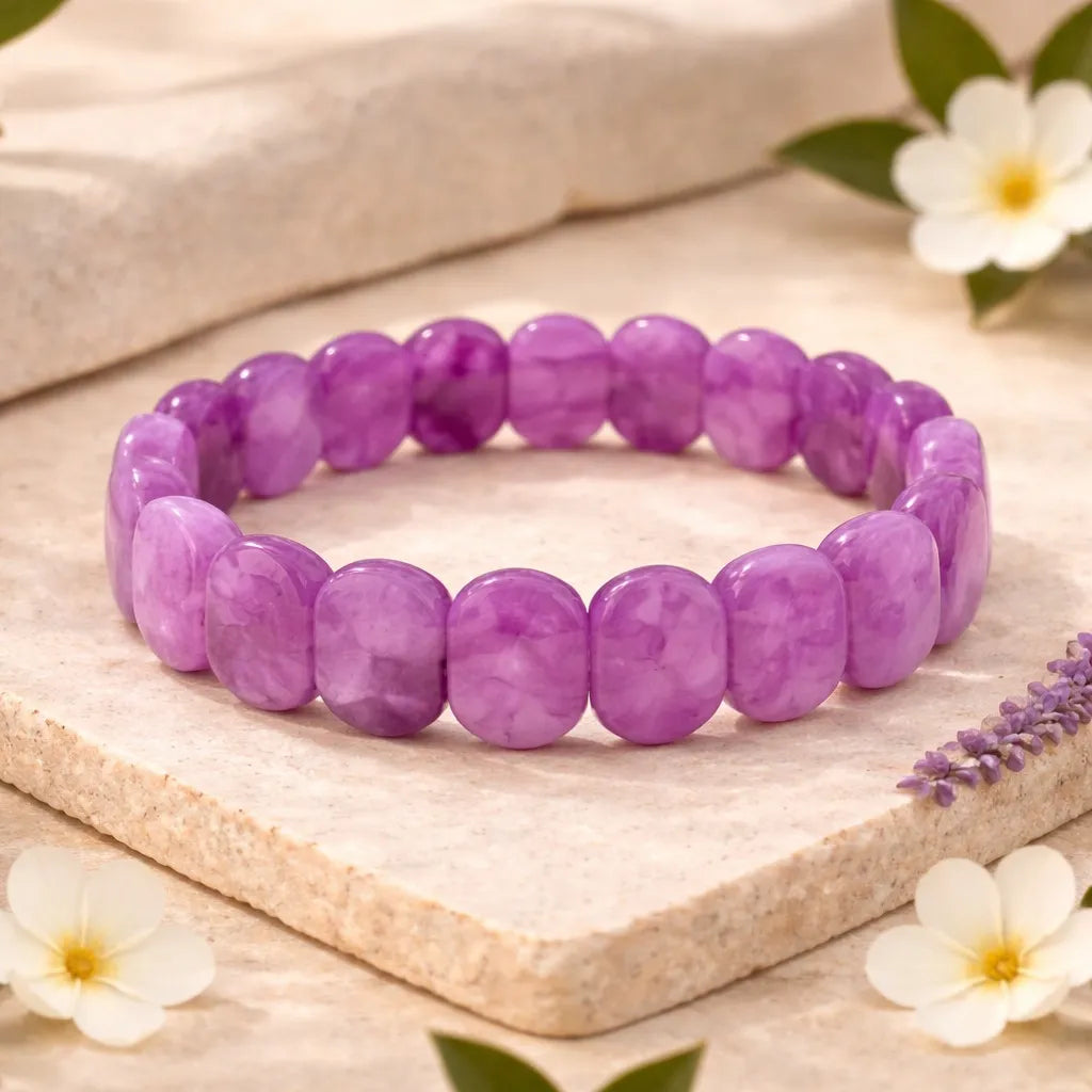 Purple beaded bracelet on a wooden surface with flowers