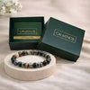 Beaded bracelet on a round wooden platform with 'Calminds' branded box in the background.