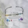 crystal bracelet with colorful beads on a card labeled new beginning against a white background.